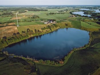 Scenic view of lake amidst agricultural field against sky