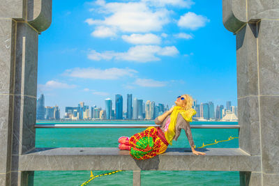 Woman sitting at beach in city