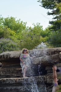 Full length of woman splashing water in park