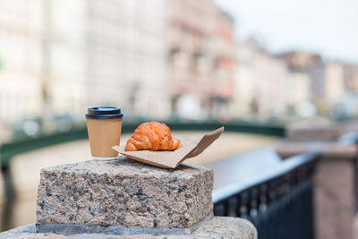 Close-up of breakfast on table against wall in city