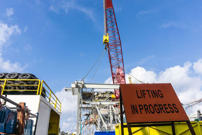 Low angle view of information sign against sky