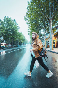 Woman smiling with umbrella against trees