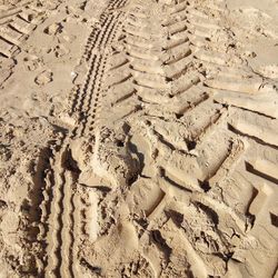 High angle view of tire tracks on sand