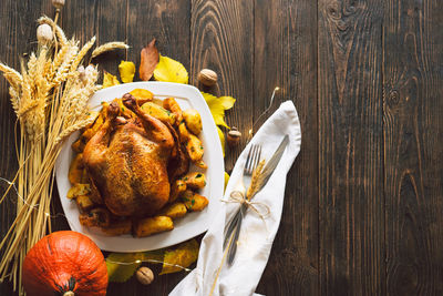 Autumn composition with leaves, ripe pumpkin and thanksgiving turkey on a dark wooden table.