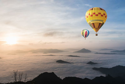 Low angle view of hot air balloons flying against sky during sunset