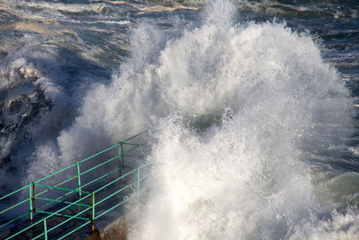 High angle view of waves splashing on sea