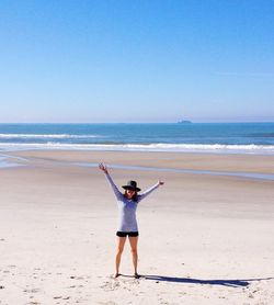Full length of boy standing on beach against clear sky