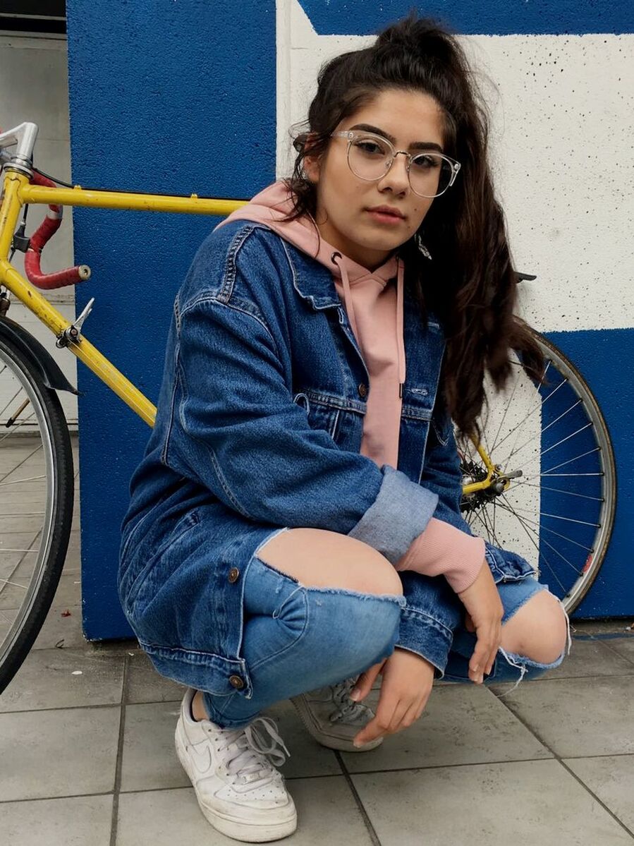 PORTRAIT OF YOUNG WOMAN WITH BICYCLE