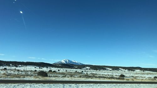 Scenic view of snowcapped mountains against clear blue sky