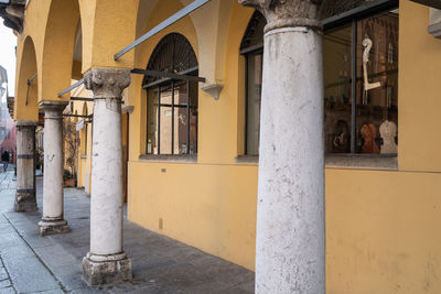 Ancient columns and arches and a luthier's store near the cathedral of cremona, lombardy - italy.