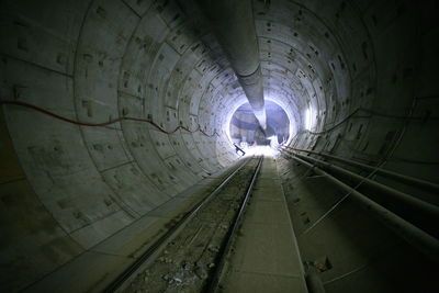 Illuminated tunnel seen through building