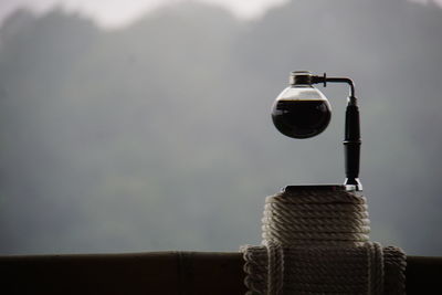 Close-up of electric lamp against sky