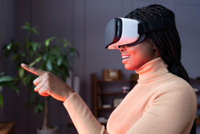 Woman in vr headset touch object in virtual reality. girl in goggles interact in digital interface