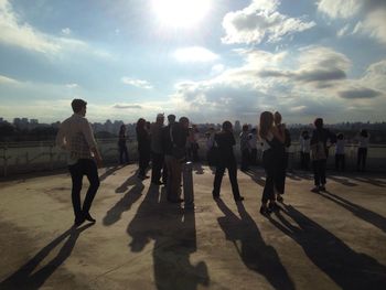 Silhouette of people against cloudy sky