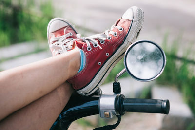 Low section of man resting on motorcycle