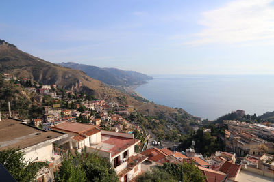 High angle view of townscape by sea against sky