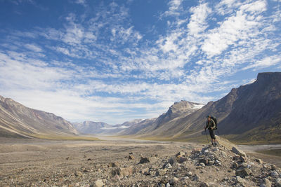 Backpacker surveys the landscape from top of glacial moraine.