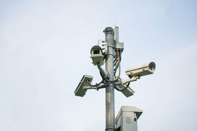 Low angle view of security cameras against clear sky