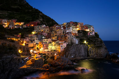 Townscape by sea against sky during sunset