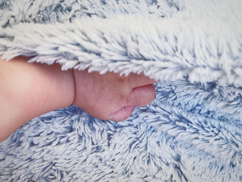 Baby hand lying on bed