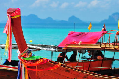 Close-up of red boat moored on sea against sky