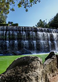 Scenic view of waterfall against sky