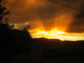 Scenic view of silhouette mountains against sky at sunset