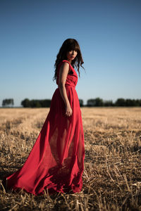 Woman standing on field against clear sky