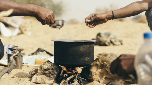 Cropped hands of hikers making tea at jaisalmer desert