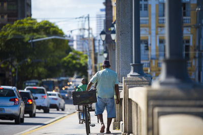 Rear view of man walking on street in city