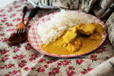 Close-up of rice with curry served in plate on sofa
