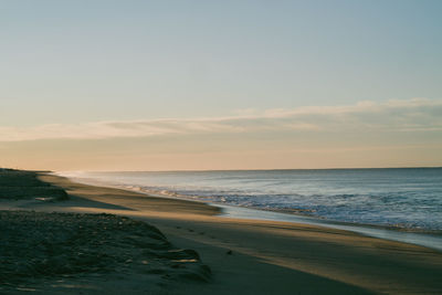 Scenic view of beach against sky during sunset