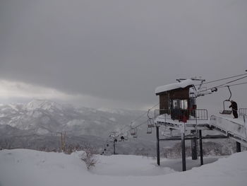 Overhead cable car on snow covered mountain against sky