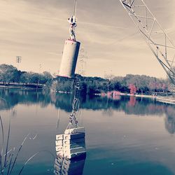 Built structure by lake against sky at sunset