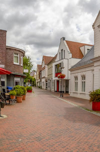 Empty alley amidst buildings against sky