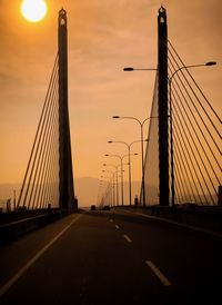 Bridge over road against sky during sunset