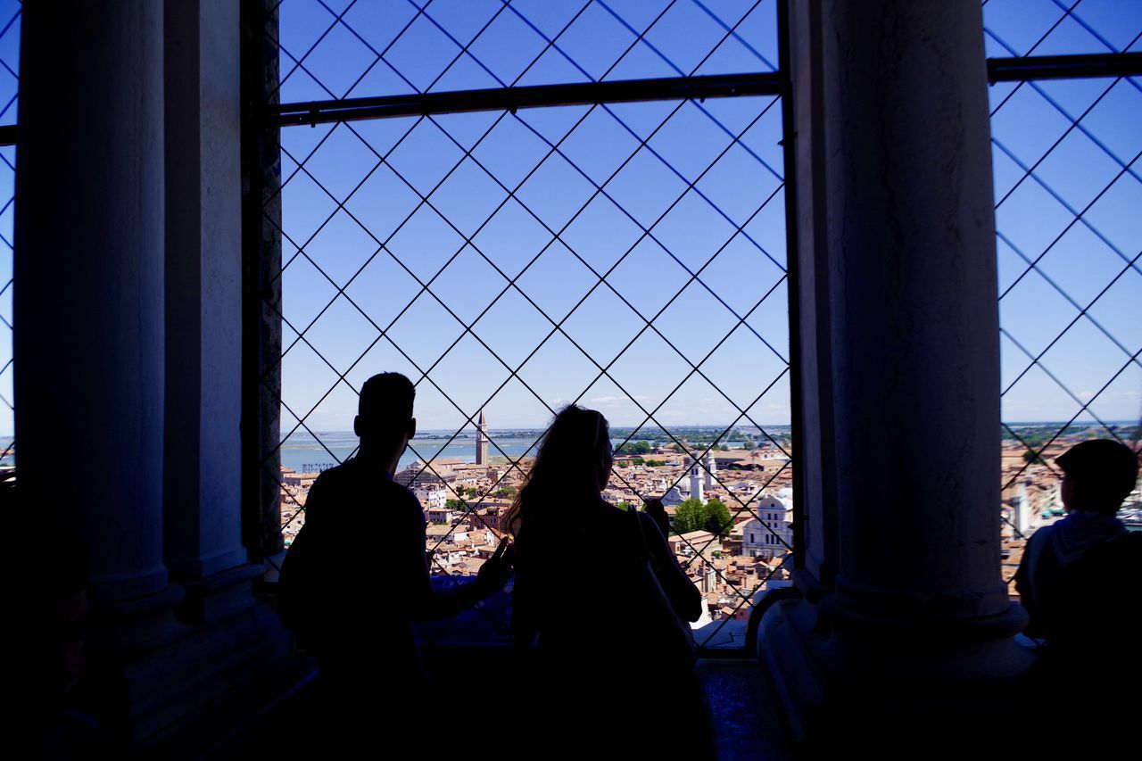 PEOPLE SITTING IN FRONT OF CITYSCAPE