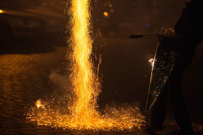 Low section of man standing by firework on street