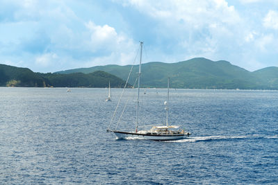 Sailboat sailing on sea against sky