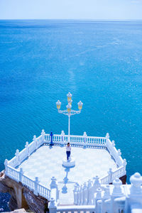 High angle view of woman standing at observation point against sea