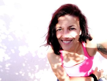 Portrait of smiling mature woman during sunny day