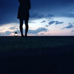 Silhouette of people standing against cloudy sky