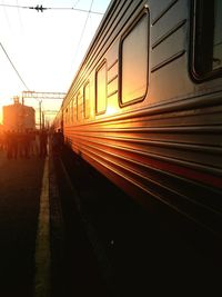 Train at railroad station against sky during sunset