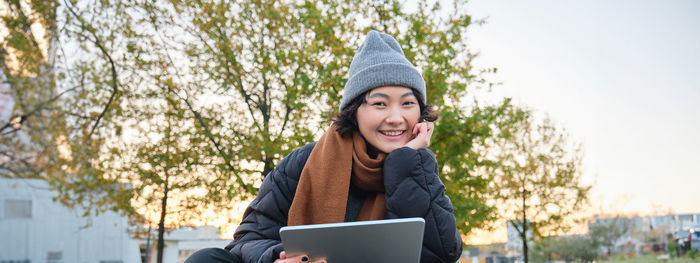 Portrait of young woman using digital tablet