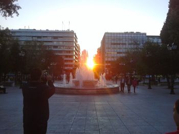 People walking in city at sunset