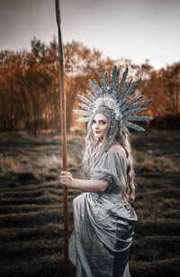 Portrait of beautiful woman wearing costume standing on field