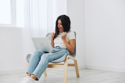 Young woman sitting on sofa at home