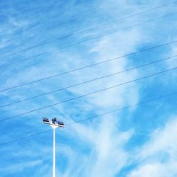 Low angle view of airplane flying against blue sky