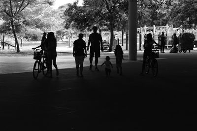 People on bicycle in city against sky