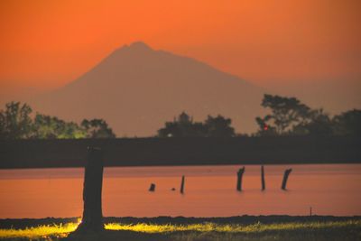 Scenic view of lake against orange sky